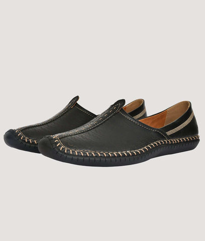 Black Big Boon men's ethnic shoes with laser design and stitched detailing against stone wall background